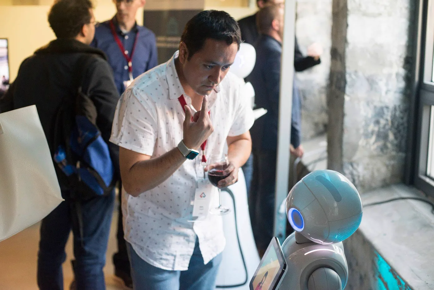 Aldo Vargas studying a Pepper humanoid robot at a technology event