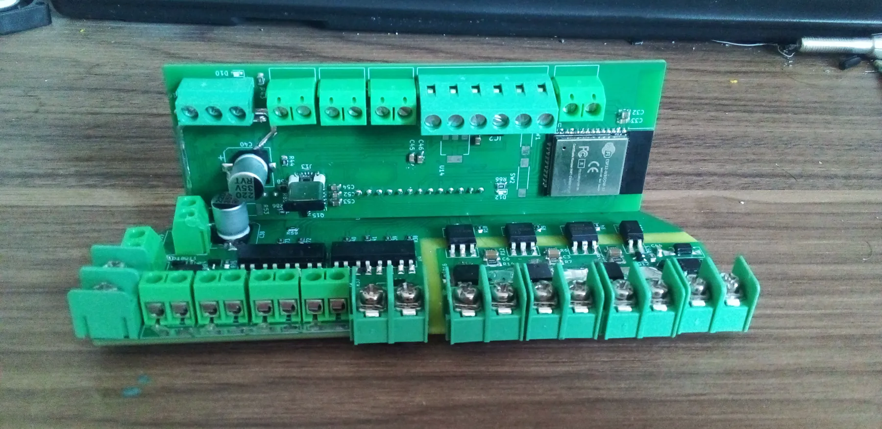 Green custom relay and power-distribution board on a workbench