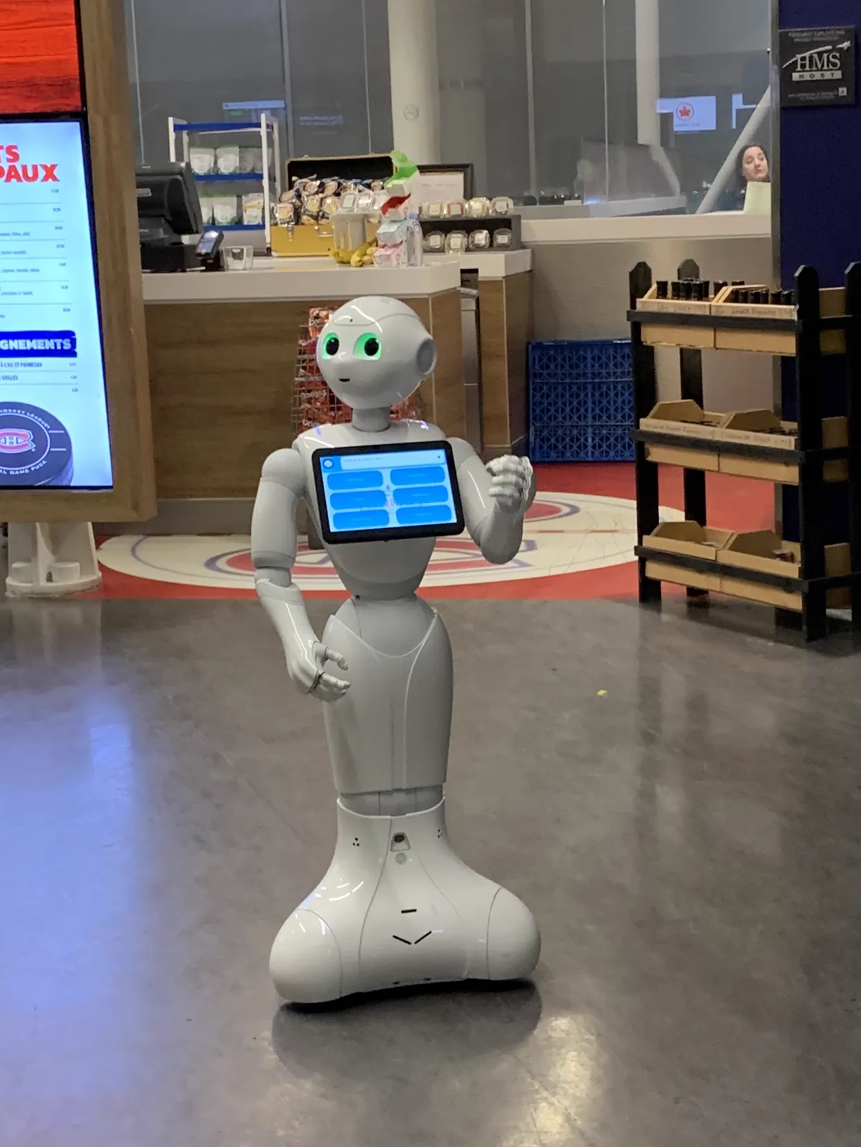 A Pepper humanoid service robot standing in a lobby space